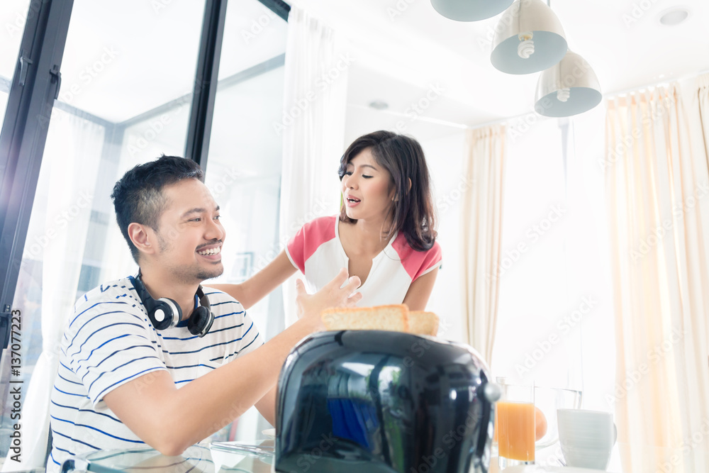 Obraz premium Asian couple having breakfast with toast and coffee