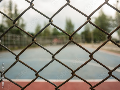 Wire fence with futsal field on background