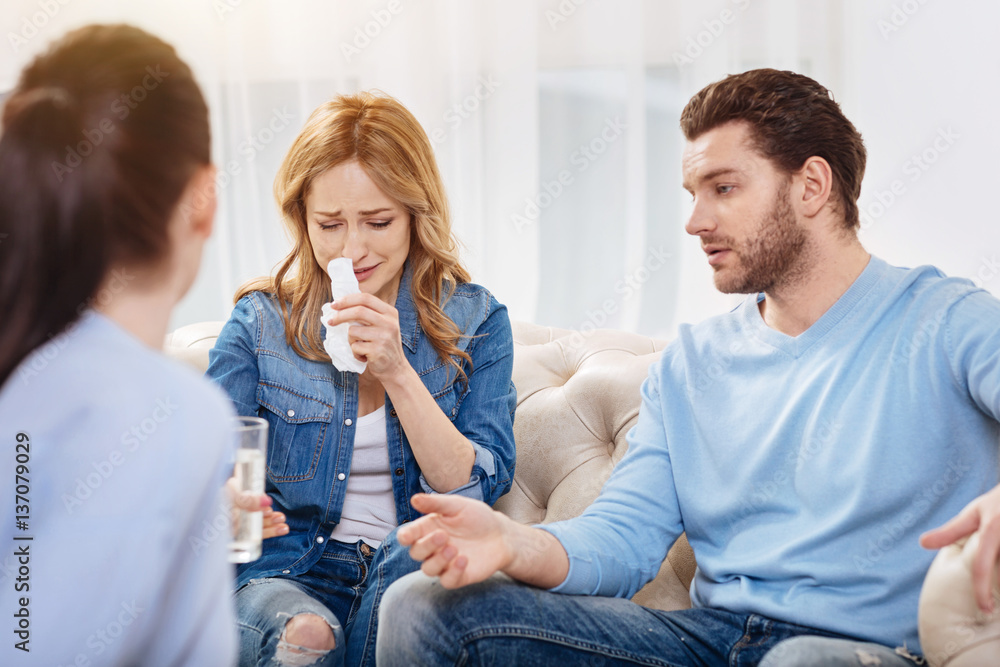 Unhappy sad woman wiping her nose with a tissue Unhappy sad woman wiping her nose with a tissue