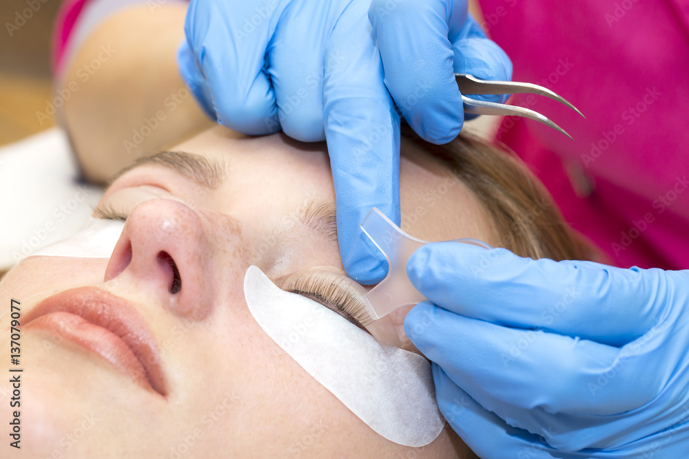 Woman on the procedure for eyelash extensions, eyelashes lamination Woman on the procedure for eyelash extensions, eyelashes lamination
