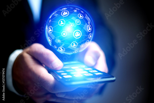 Businessman holding smartphone with network globe sphere hologra