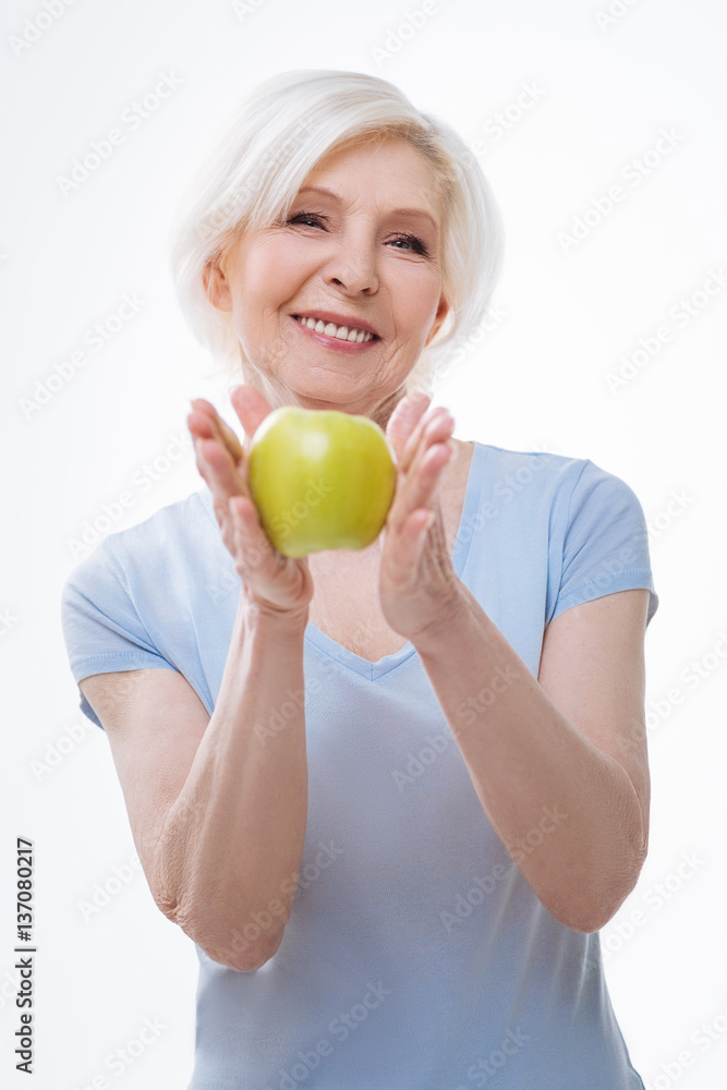 Happy smiling woman keeping apple in both hands Happy smiling woman keeping apple in both hands