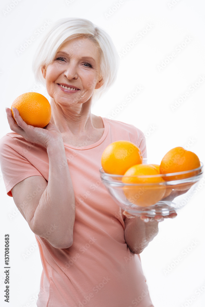 Positive delighted aged blonde demonstrating big orange Positive delighted aged blonde demonstrating big orange