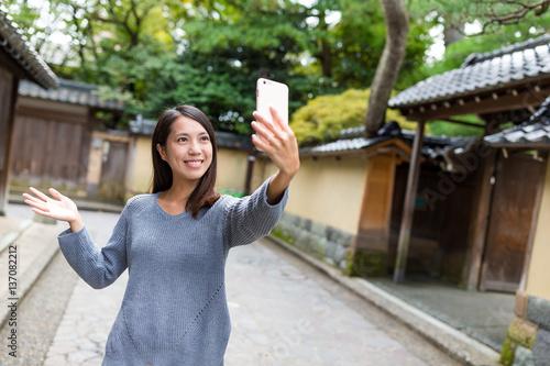 Woman taking selfie photo with mobile phone in kanazawa