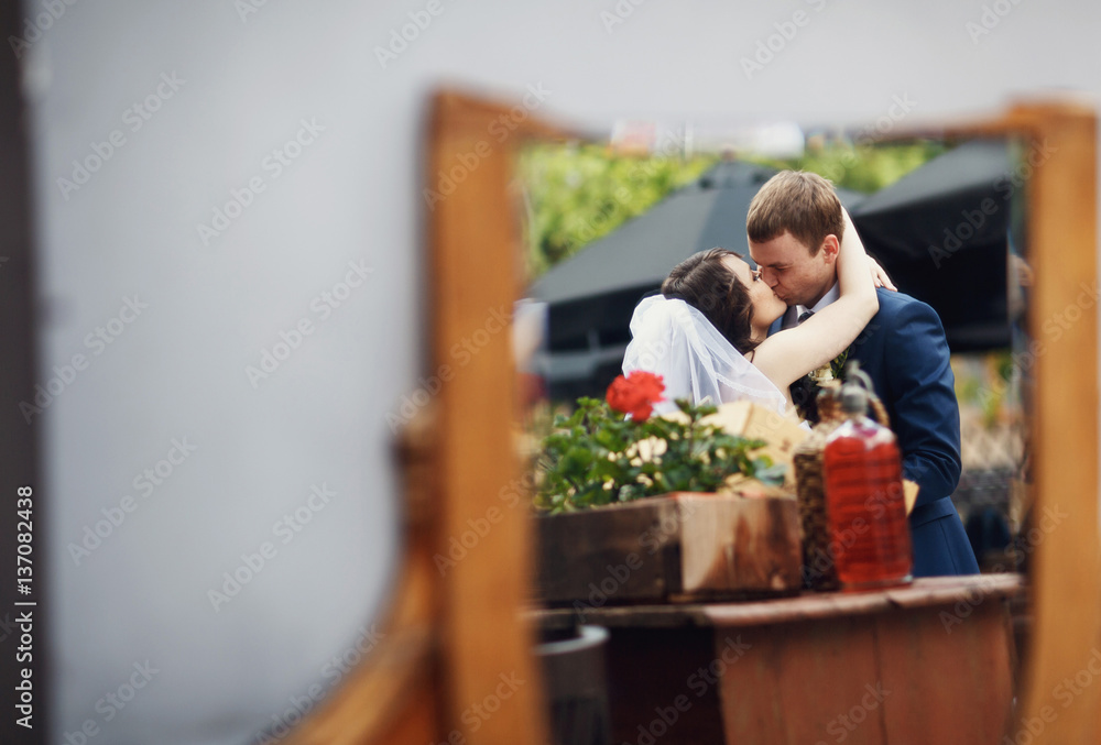 Fototapeta premium Newlyweds kissing passionately in the street