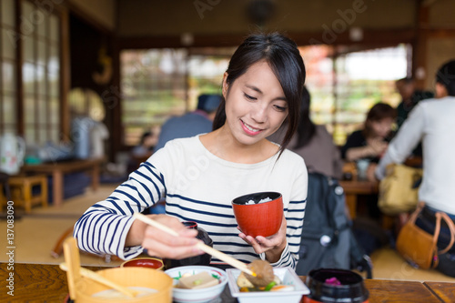 Woman eating rice in japanese restaurant