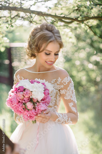 Incredibly beautiful bride with bouquet of pink flowers