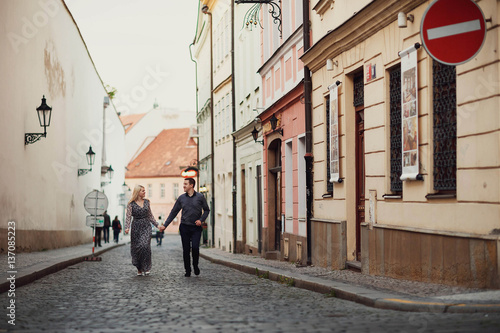 young woman and man walking on the old street together © myronovychoksana