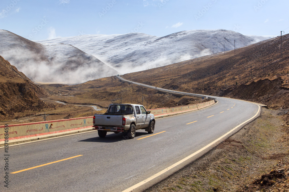 Pickup truck on the road, Beautiful winter road in Tibet under snow mountain Sichuan China - obrazy, fototapety, plakaty 