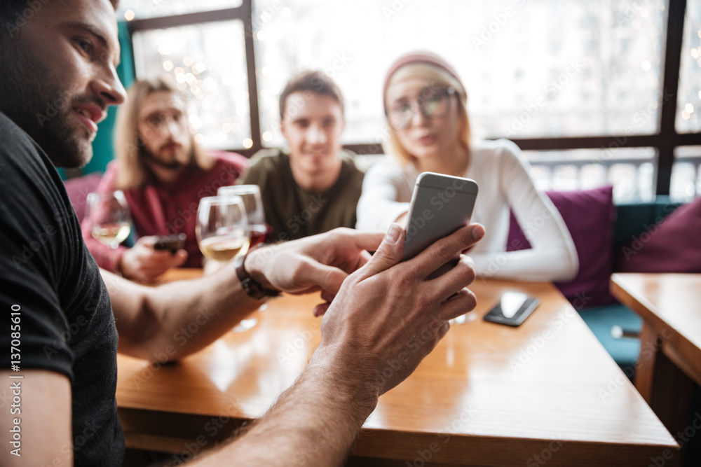 Attractive friends sitting in cafe and looking at phone. Attractive friends sitting in cafe and looking at phone.