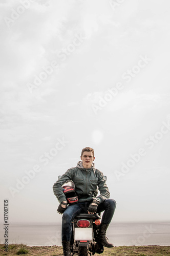 Fototapeta Naklejka Na Ścianę i Meble -  Sitting on the motorbike near sea