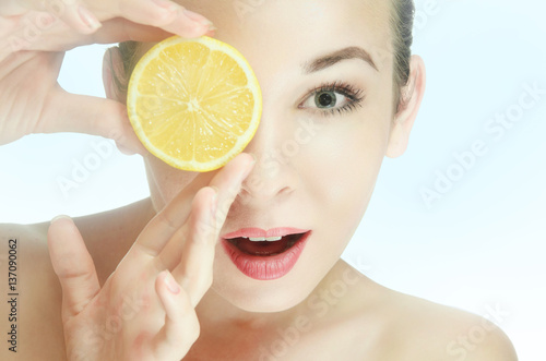 beauty, young woman with one halves of a lemon