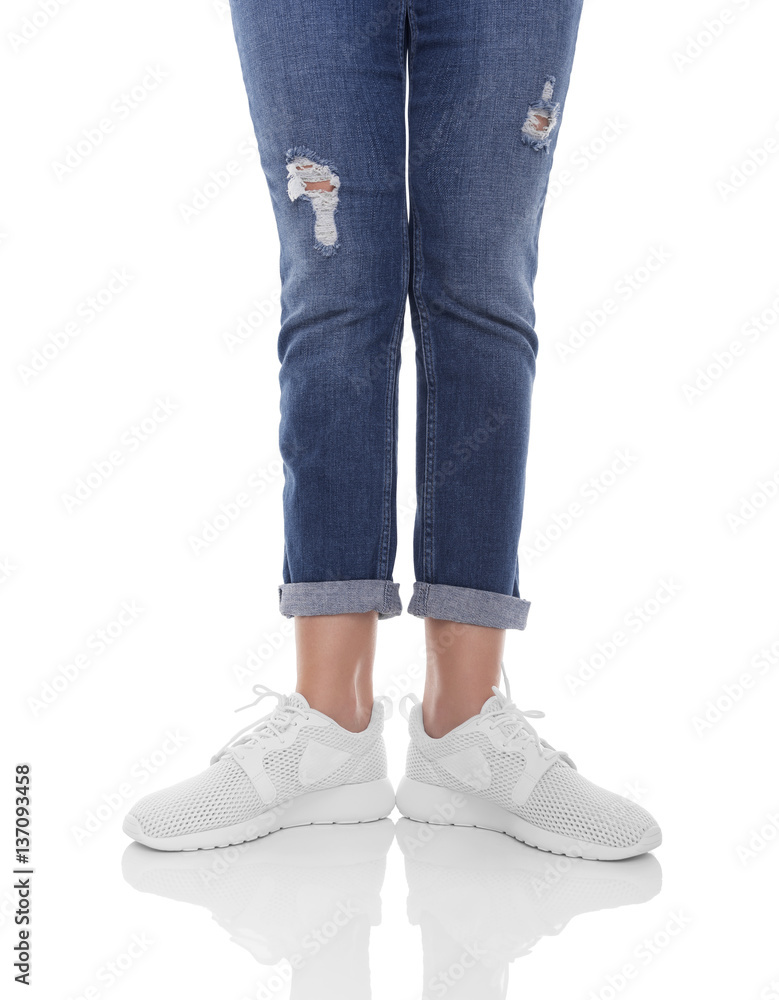 Women's legs in jeans and sneakers. Women's legs in jeans and sneakers.