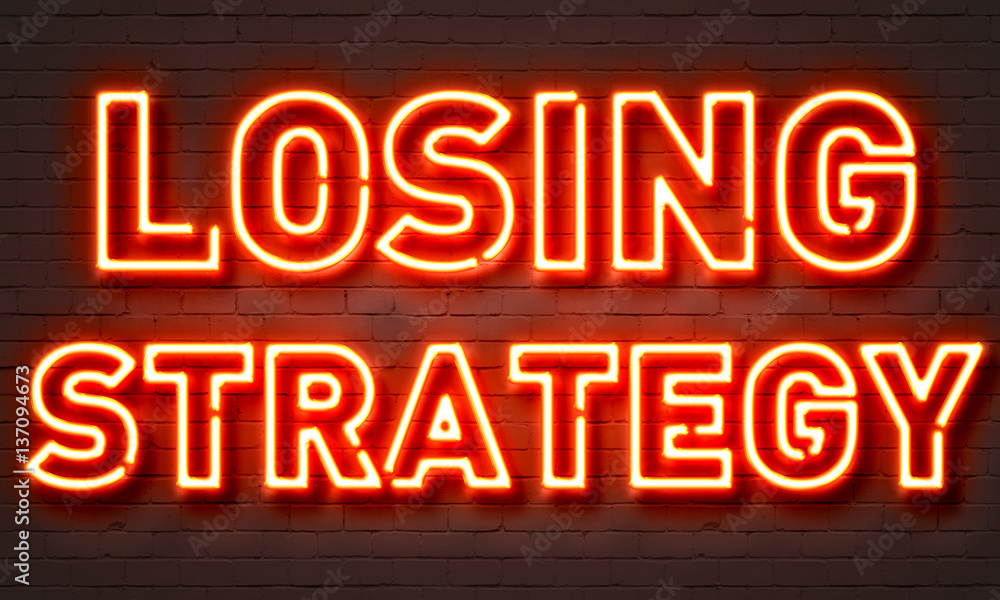 Losing strategy neon sign on brick wall background.