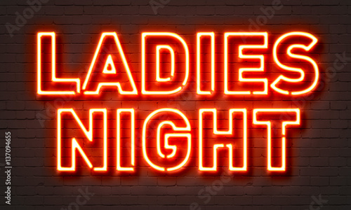 Ladies night neon sign on brick wall background.