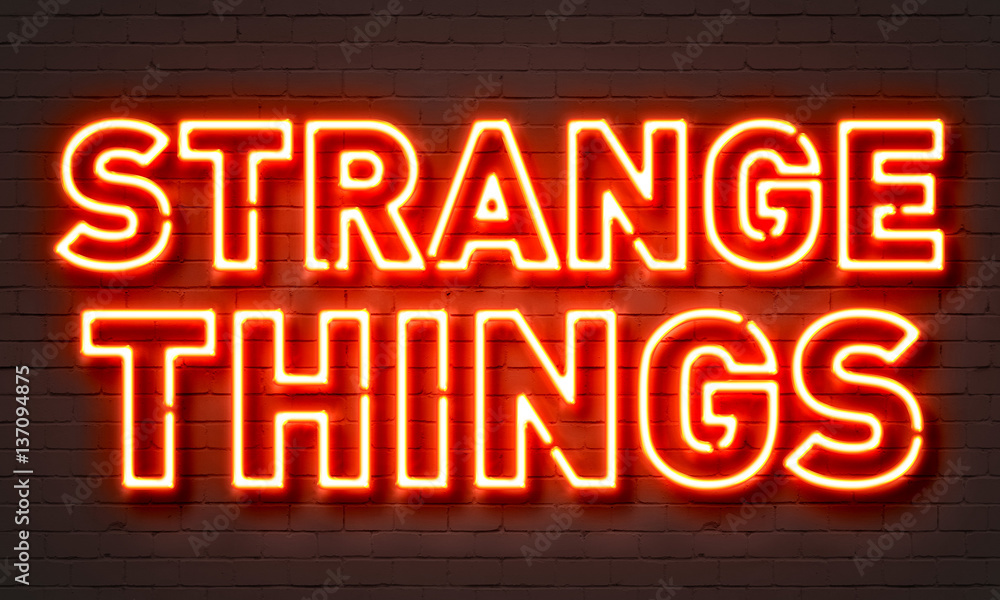 Strange things neon sign on brick wall background.