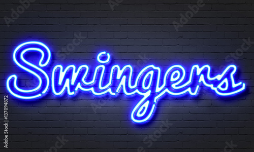 Swingers neon sign on brick wall background. photo