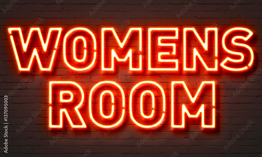 Womens room neon sign on brick wall background.