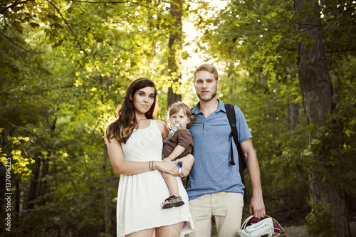 Portrait of happy parents with daughter in forest photo