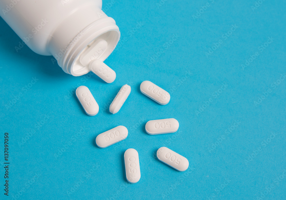 white pills and pill bottle on blue sky background. white pills and pill bottle on blue sky background.