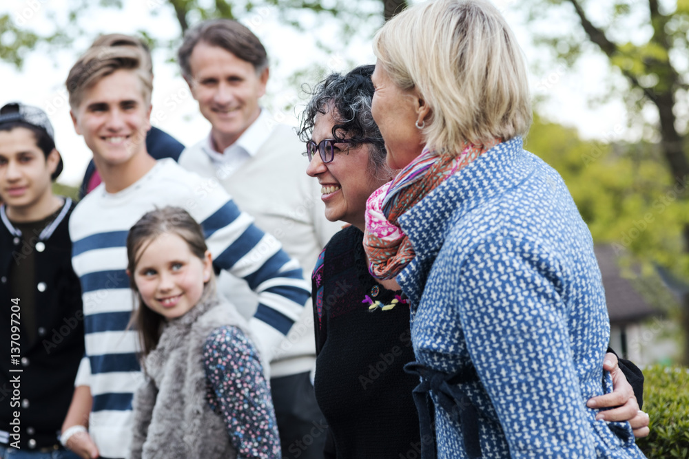 Smiling mature woman with family and friends at yard Smiling mature woman with family and friends at yard