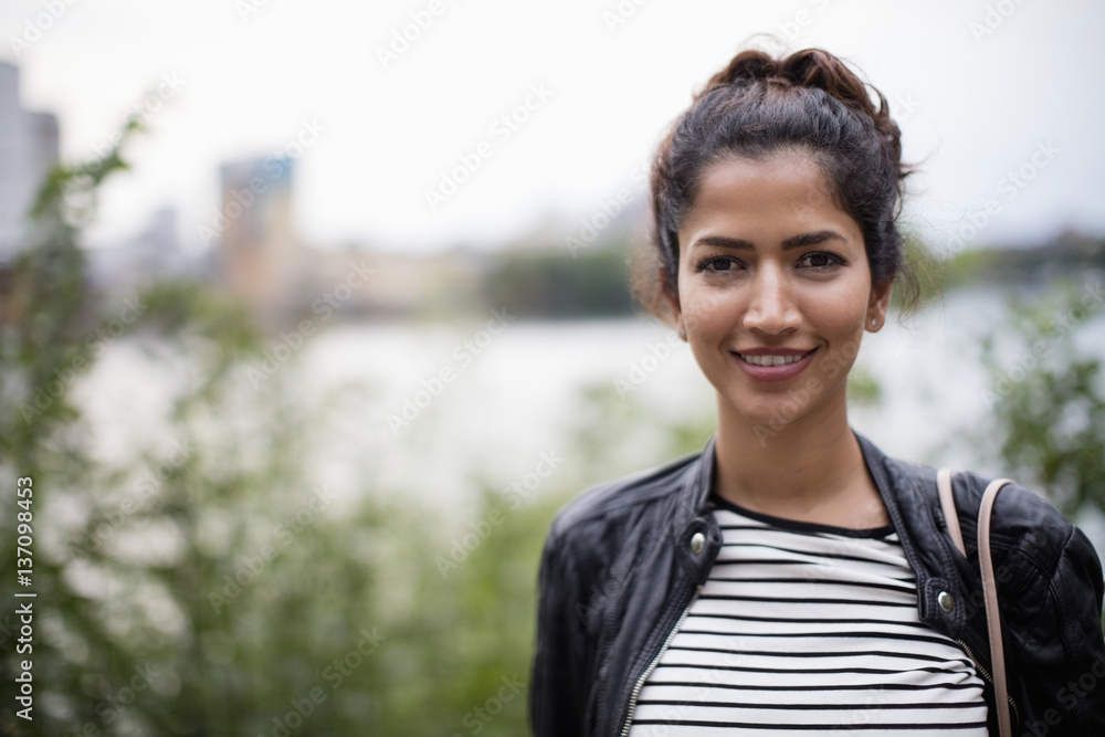 Portrait of smiling woman standing against plants and river Portrait of smiling woman standing against plants and river
