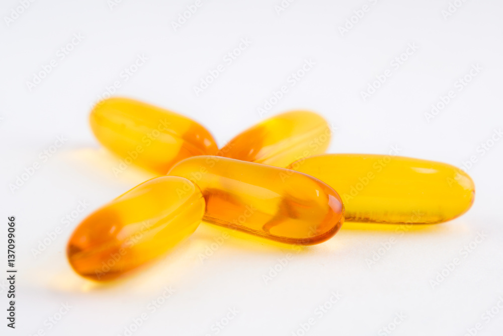 Yellow pills capsules or fish oil on white background Yellow pills capsules or fish oil on white background