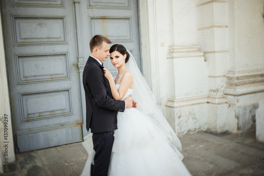 Wedding. Wedding day. Beautiful bride and elegant groom walking after wedding ceremony. Luxury bridal dress and bouquet of flowers. Bride and groom at wedding day
