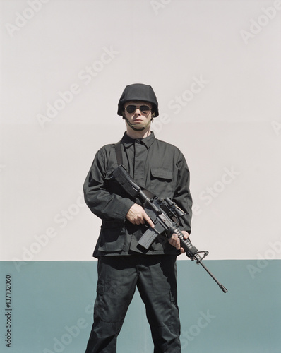 Man wearing special forces uniform and holding high powered semi-automatic rifle