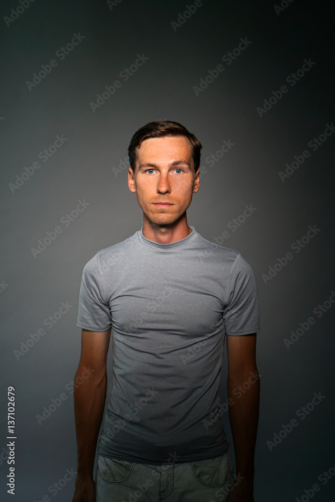 Young man in t-shirt on gray background.