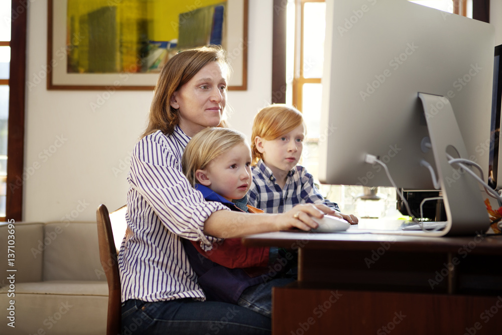 Mother and sons using computer at home Mother and sons using computer at home