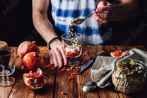 Photos Man Puts Granola into the Glass.
