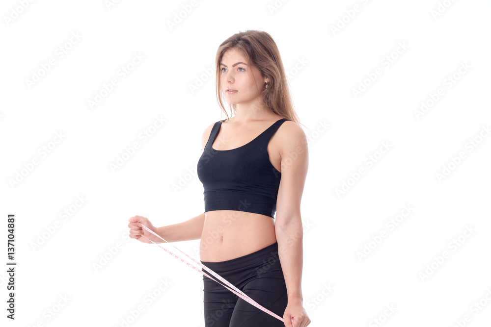 serious slender girl standing sideways which holds the measuring tape serious slender girl standing sideways which holds the measuring tape