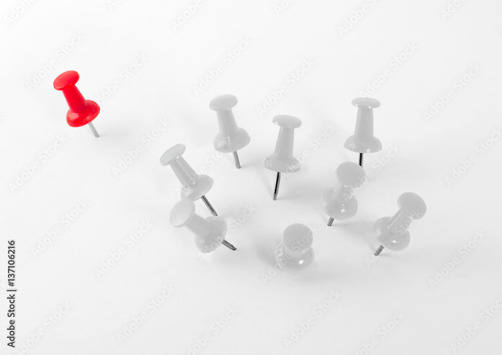 Red push pin separated from white push pins group Red push pin separated from white push pins group