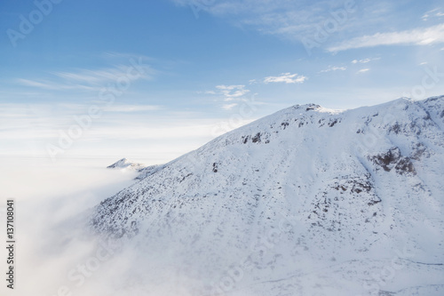 Low clouds envelops the snowy mountain peak in the Tatras.