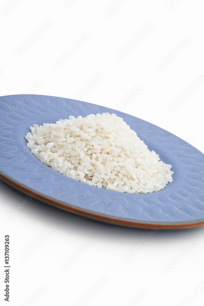 Rice, pile on blue ceramic plate. Isolated on white background Rice, pile on blue ceramic plate. Isolated on white background