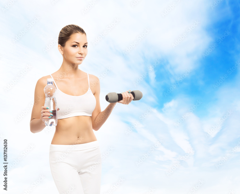 Young, sporty, fit and beautiful girl with the dumbbell over sky background. Healthy lifestyle and weight losing concept. Young, sporty, fit and beautiful girl with the dumbbell over sky background. Healthy lifestyle and weight losing concept.