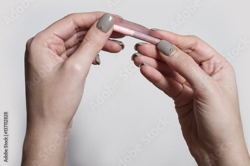 Hands of a woman rolling a cigarette with rolling tobacco on clear background.