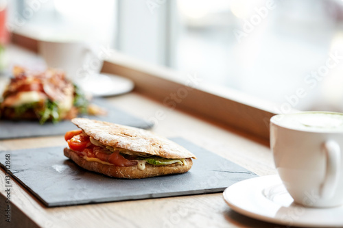 salmon panini sandwich on stone plate at cafe