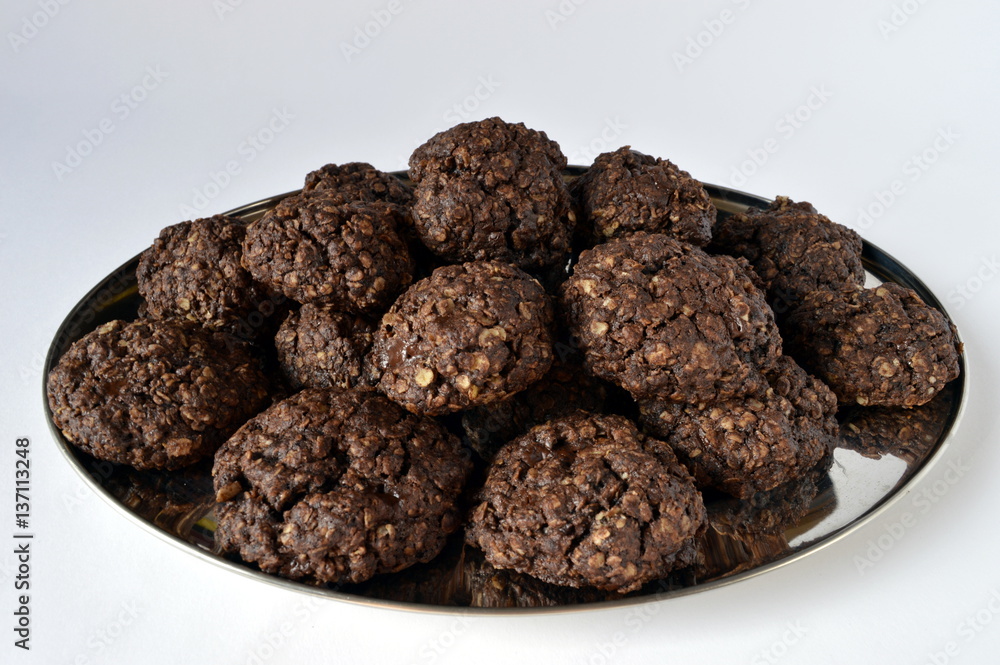 Homemade double chocolate oatmeal cookies on silver platter Homemade double chocolate oatmeal cookies on silver platter