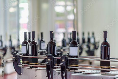 Red wine bottling and sealing conveyor line at winery factory