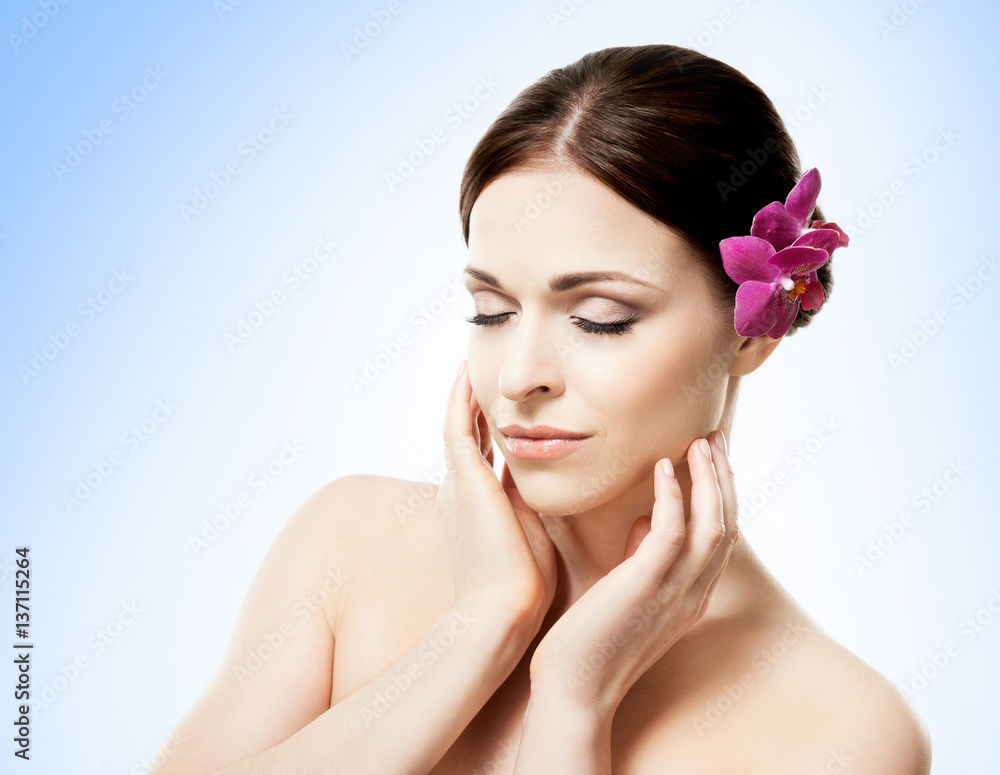 Close-up portrait of a beautiful girl with an orchid flower in her hair. Health, treatment, spa concept. Close-up portrait of a beautiful girl with an orchid flower in her hair. Health, treatment, spa concept.