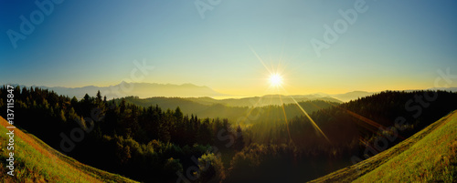 Summer High Tatras mountain landscape. Sunrise at monumental hills. Golden colored forest and peaks. Fog and inversion