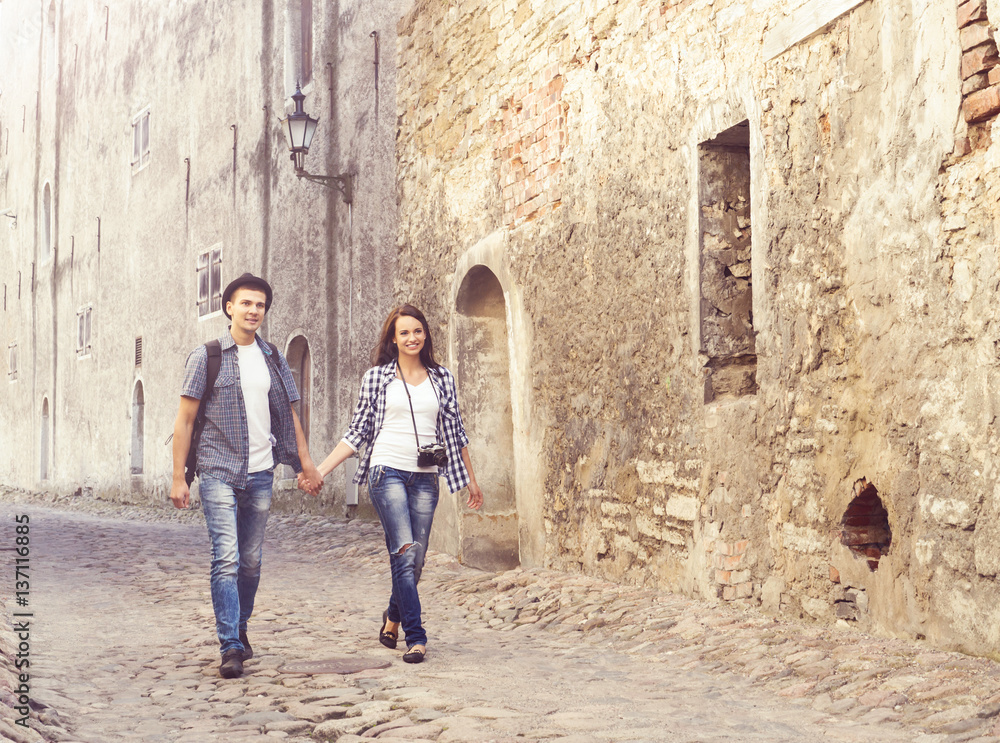 Traveling couple of hipsters: walking around old town. Vacation, summer, holiday, tourism: concept.