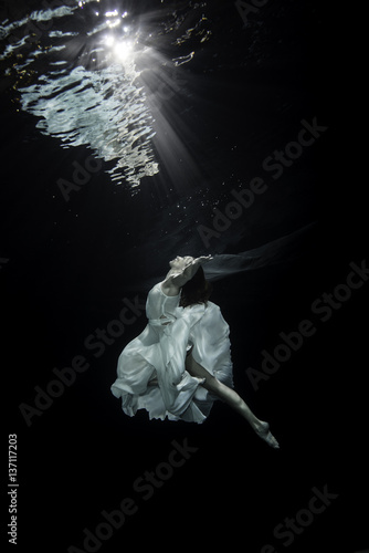 Young female ballet dancer dancing underwater