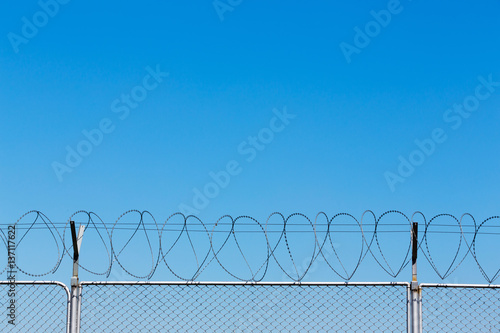 Barbed wire fence on blue sky