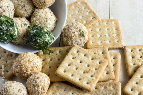 Cheeseballs with crackers on light wood background