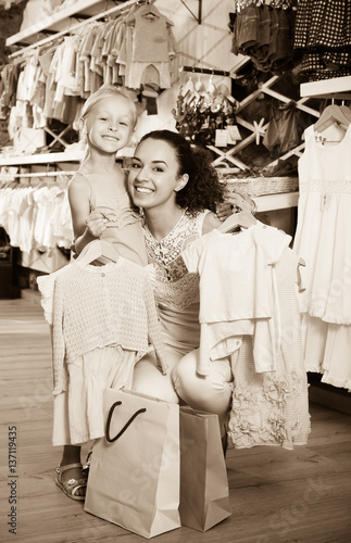 Happy woman with small child holding clothes
