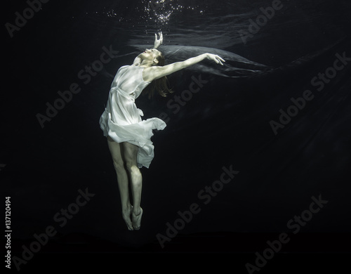 Young female ballet dancer dancing underwater