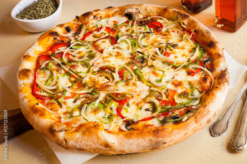 Pizza with tomato, cheese, bell pepper, onions and mushrooms.